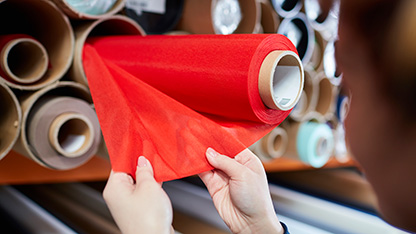 osoba, která zkoumá textil