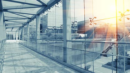 Moderní prosklená budova s ​​celookenním chodníkem